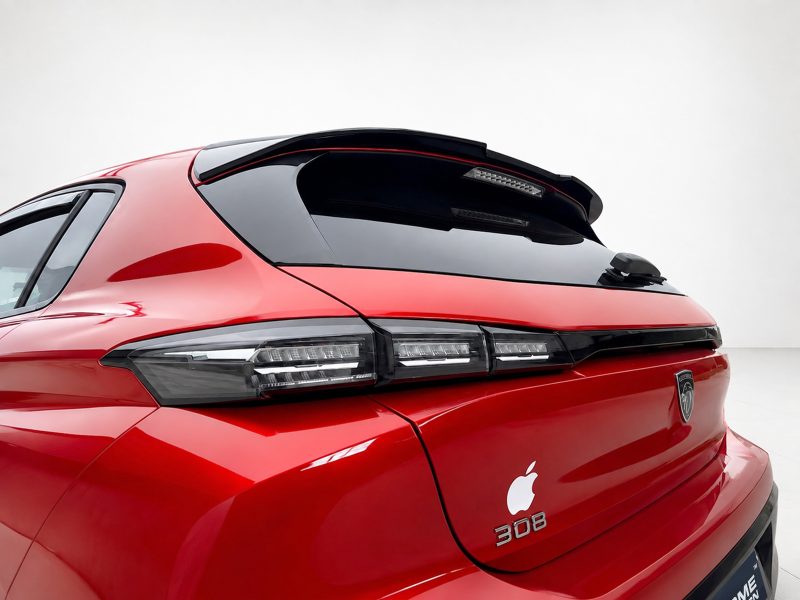 A-492_4jpg - OPSHOLDERS Red hatchback rear with black roof spoiler, sleek LED taillights, and an Apple logo decal on the trunk badge area