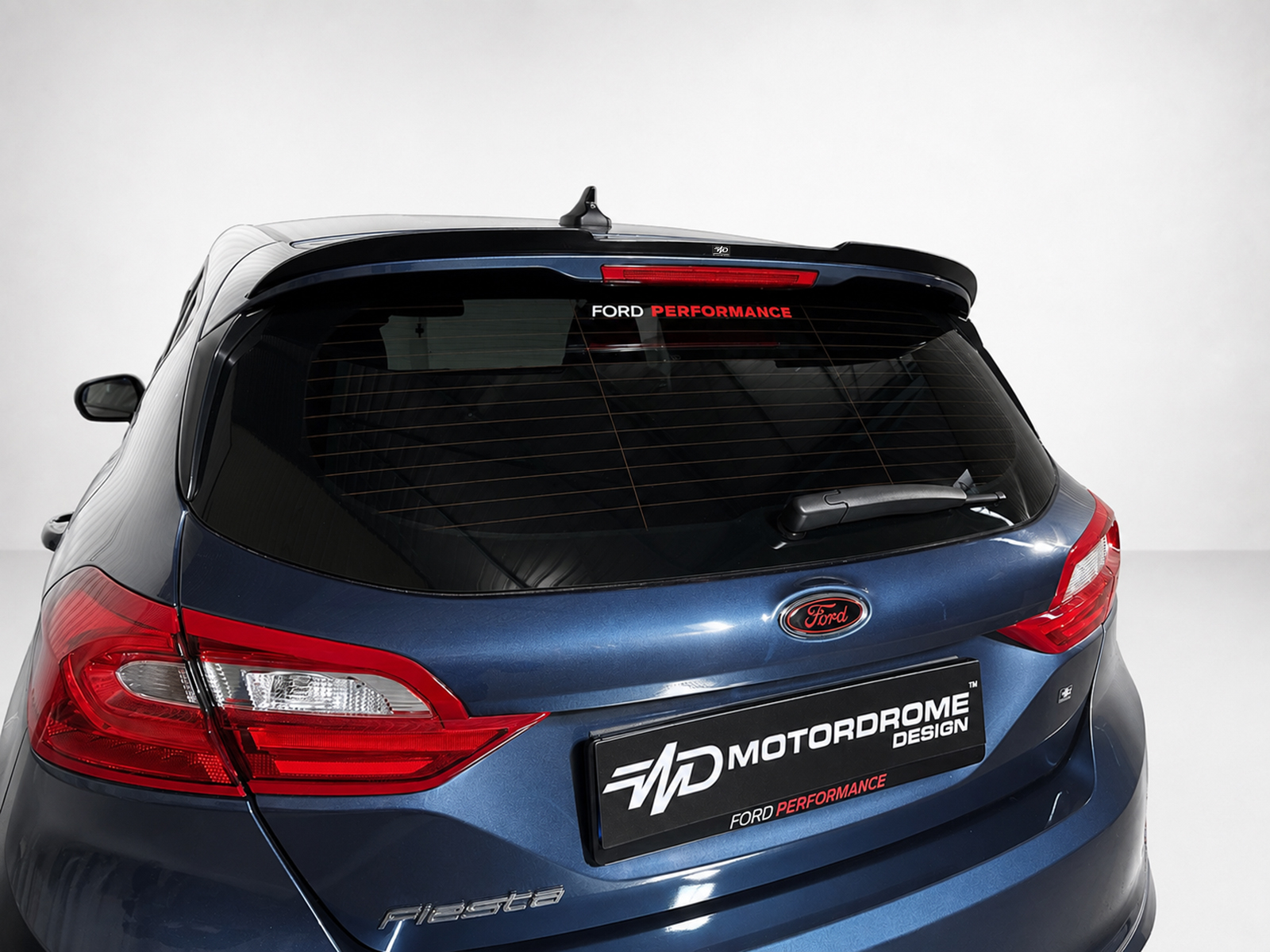A-493_1jpg - OPSHOLDERS Blue Ford hatchback rear view with Ford logo and 'Performance' decal on the rear window.