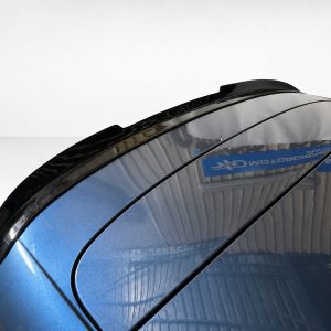 A-493_3jpg - OPSHOLDERS Close-up of a glossy blue car roof with black trim and reflections from the surroundings, highlighting the curved panels and seam lines.