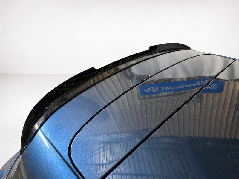 A-493_3jpg - OPSHOLDERS Close-up of a glossy blue car roof with black trim and reflections from the surroundings, highlighting the curved panels and seam lines.