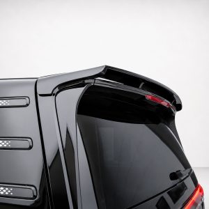 Close-up of the rear corner of a black SUV, showing a spoiler, tinted rear window, and taillights on a plain background.