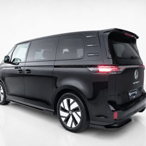 Black Volkswagen ID. Buzz electric van, rear-left three-quarter view in a white studio, taillights illuminated.