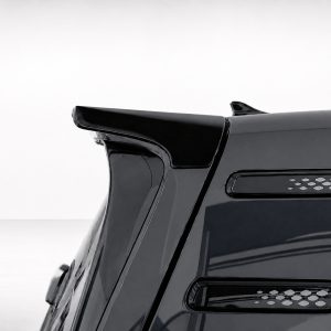 Close-up of a black sports car rear spoiler and vented side panel on a glossy body edge.