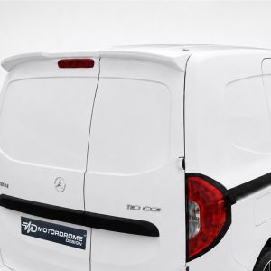 Rear view of a white Mercedes van with closed rear doors, red taillights, and a black rear bumper; shows a vehicle badge and a design sticker reading 'Motordrome Design' on the tail.