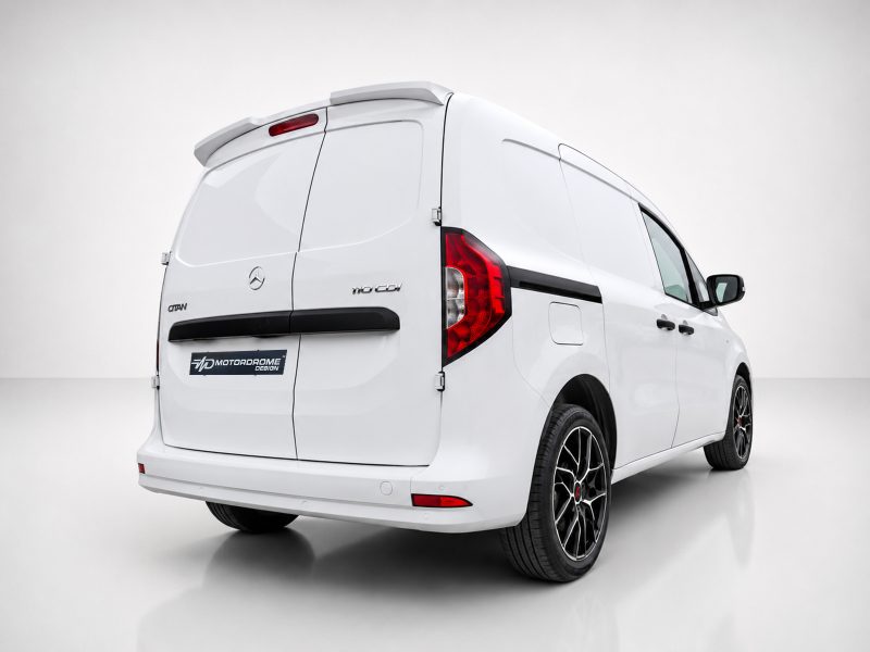 White Mercedes-style cargo van shown from a rear three-quarter angle in a studio, highlighting its rear doors and aftermarket alloy wheels.