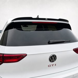 Rear view of a white Volkswagen SUV showing the GTI badge and VW emblem, with red taillights and rear wiper visible on the back window.