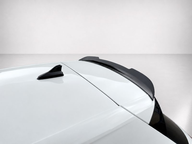 A-496_4jpg - OPSHOLDERS Close-up of a white car roof with a black shark-fin antenna and a rear spoiler.