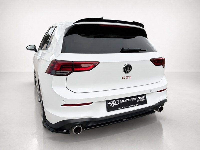 A-496_5jpg - OPSHOLDERS Rear view of a white VW SUV with GTI badge and aftermarket exhaust, in a studio setting with a black rear spoiler and dark taillights.