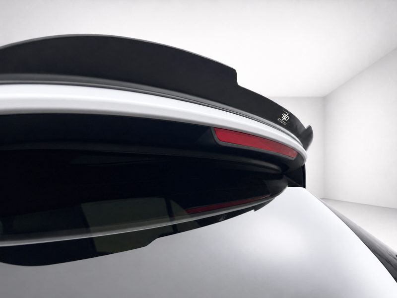 A-496_6jpg - OPSHOLDERS Close-up of a car's rear spoiler with a red taillight strip and black aerodynamic spoiler edge.