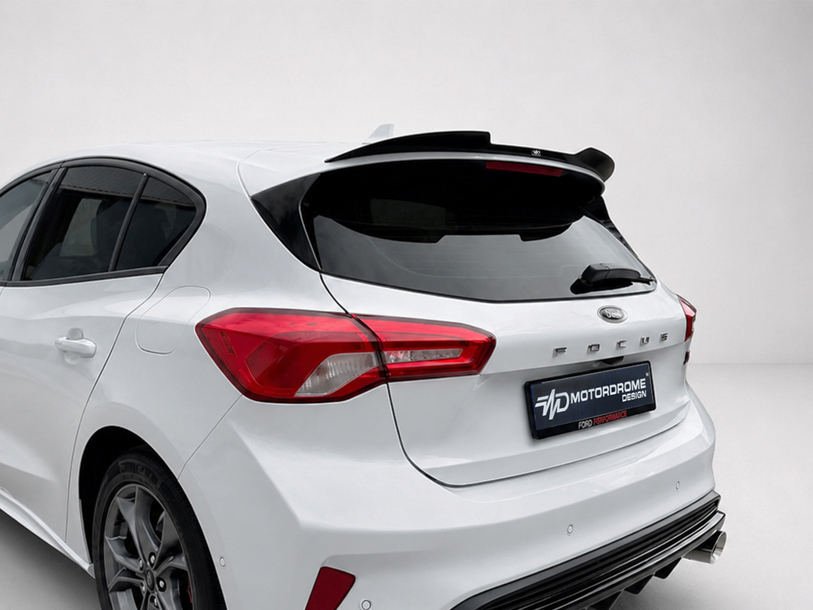 A-497_1jpg - OPSHOLDERS Rear-right view of a white hatchback with prominent red tail lights, spoiler, and dark rear window glass.