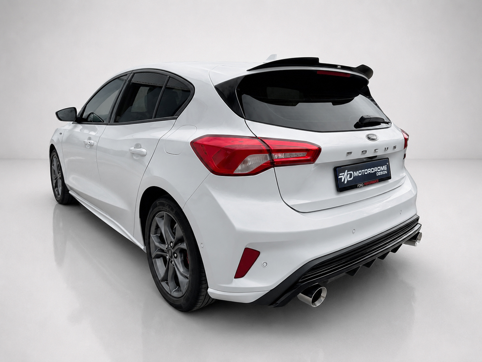 A-497_2jpg - OPSHOLDERS Rear three-quarter view of a white Ford hatchback with red taillights, black rear window, and dual exhausts in a studio setting