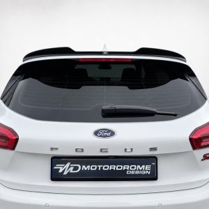 A-497_6jpg - OPSHOLDERS Rear view of a white Ford Focus hatchback with a black roof spoiler and MOTORDROME DESIGN plate on the bumper.