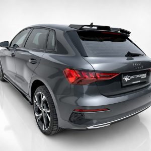 Rear three-quarter view of a gray Audi SUV with a sporty rear spoiler and large alloy wheels
