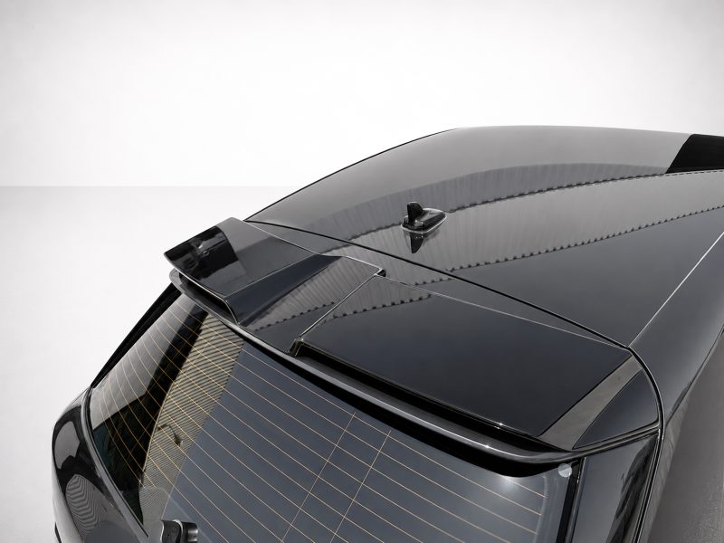 Rear view of a dark gray car showing the roof spoiler and antenna on a clean studio background.
