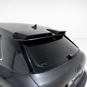 Rear view of a dark gray Audi SUV with a roof spoiler and rear wiper on a light background.