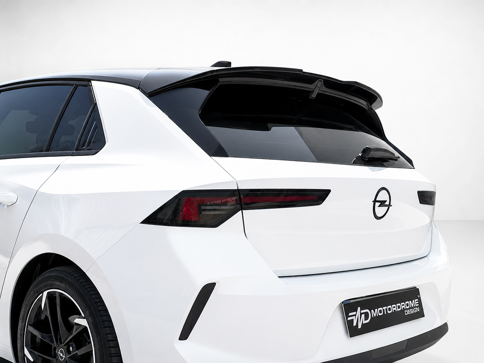 A-501_1jpg - OPSHOLDERS White crossover SUV rear with black roof spoiler and Opel emblem on the tailgate.