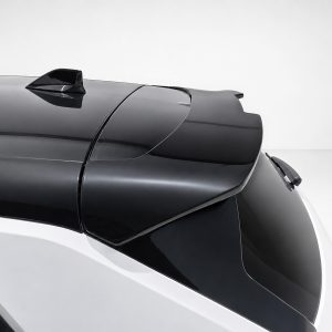 A-501_3jpg - OPSHOLDERS Close-up of a glossy black car roof with a shark-fin antenna and a rear spoiler visible at the back edge of the roof surface.