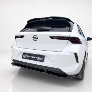A-501_5jpg - OPSHOLDERS Rear three-quarter view of a white Opel hatchback parked on a showroom floor, featuring a Motordrome Design plate on the bumper.