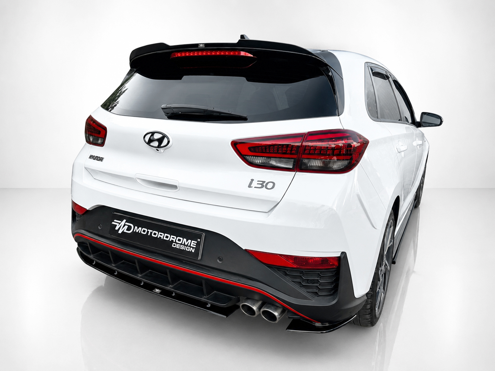 A-502_2jpg - OPSHOLDERS Rear view of a white Hyundai i30 hatchback in a studio setting, showing red taillights and a black rear spoiler with a red trim.