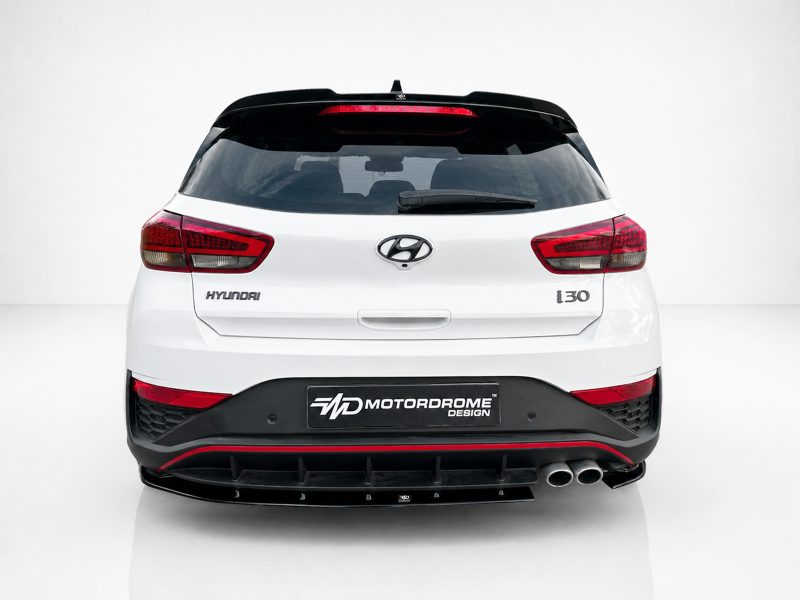 A-502_3jpg - OPSHOLDERS Rear view of a white Hyundai i30 hatchback, showing red taillights, black rear diffuser, and a Motordrome Design plate on the bumper.