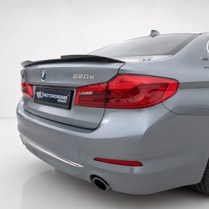 Rear view of a silver BMW 620d sedan with red tail lights and a MotorDrome Design plate on the trunk lid
