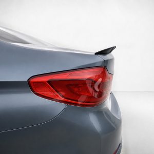 Rear of a silver car, showing the red taillight and small spoiler on the trunk edge