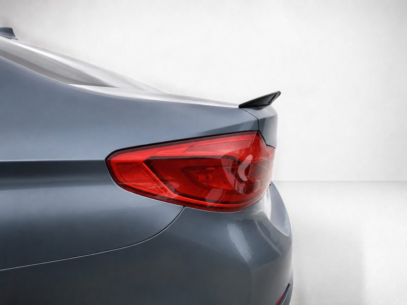 Rear of a silver car, showing the red taillight and small spoiler on the trunk edge
