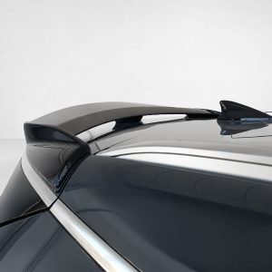 Close-up of a sleek car spoiler on a dark, glossy vehicle with reflections along the trunk edges.