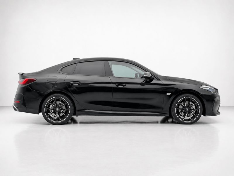 Side view of a black four-door sedan with large alloy wheels in a white studio backdrop.