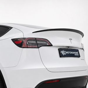 Rear three-quarter view of a white electric SUV with a black spoiler and distinctive taillights, showing a custom 'MOTOR DOME DESIGN' plate area.