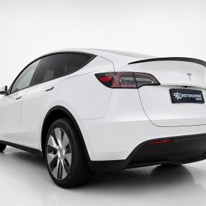 White electric car shown from the rear three-quarter view in a studio setting with a black spoiler and tinted windows.