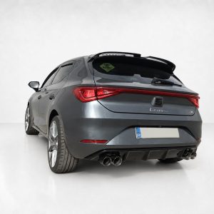 Rear three-quarter view of a gray SEAT Leon FR hatchback in a studio with a white backdrop, showing dual exhausts and red taillights.