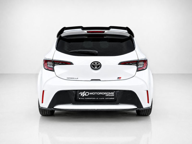 A-511_4jpg - OPSHOLDERS Rear view of a white Toyota Corolla hatchback in a minimalist studio, showing the taillights, rear window, and badge.