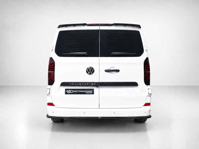 Rear view of a white Volkswagen Transporter van with split doors, dark rear windows, and a Motorodome Design badge on the bumper area.