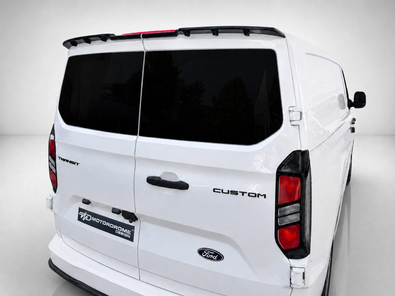 Rear view of a white Ford Transit Custom van with dark rear windows and 'Custom' badge visible on the tail door.