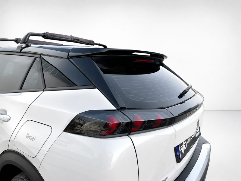 A-513_5jpg - OPSHOLDERS Rear quarter view of a white SUV showing a black roof rack and rear wiper on the rear window