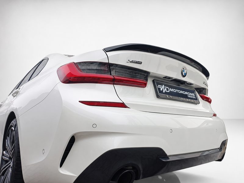 White BMW car rear view with XDrive badge and red taillights on a white backdrop