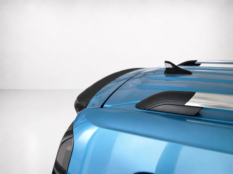 A-516_4jpg - OPSHOLDERS Close-up of a blue car's hood and roof with black accents and roof rails visible on the right side.