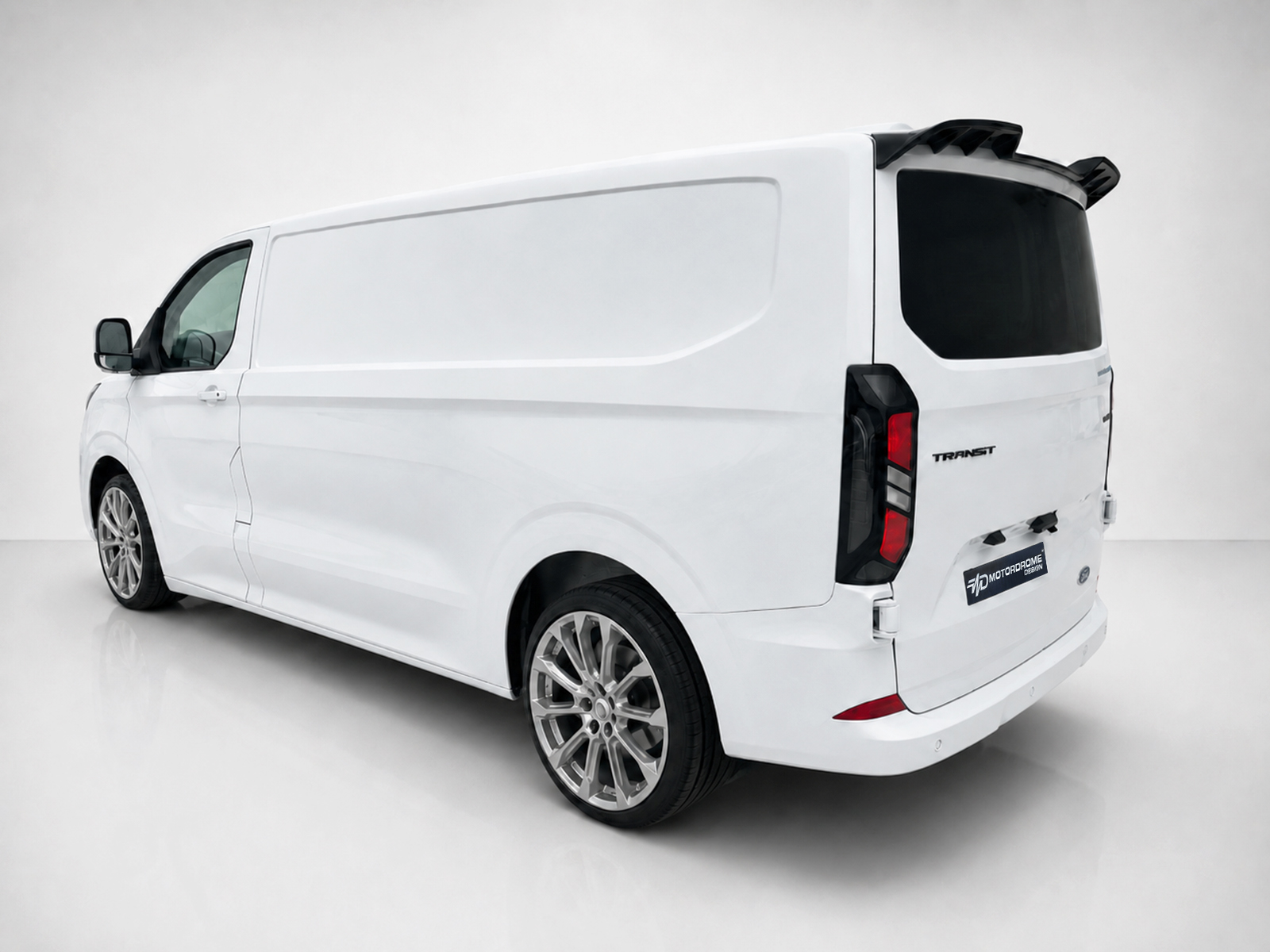 A-517_2jpg - OPSHOLDERS Rear three-quarter view of a white cargo van in a studio setting, with dark rear window and alloy wheels close-up.