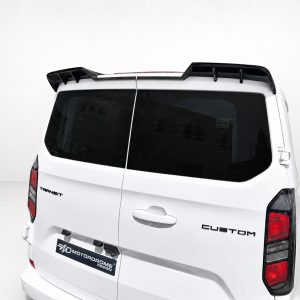 White van rear view with dark glass windows and a black roof spoiler; badge reads Transit Custom on the tailgate.