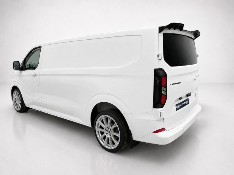 White cargo van shown from a rear-left angle in a clean, studio setting, highlighting its large cargo area and tinted rear window.