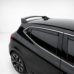 Close-up of the rear side of a black SUV showing chrome trim, tinted windows, and roof rails on a light background.] ,