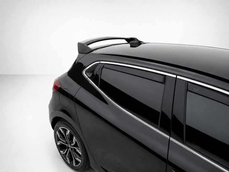 Close-up of the rear side of a black SUV showing chrome trim, tinted windows, and roof rails on a light background.] ,