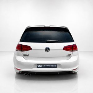 A-521_4jpg - OPSHOLDERS Rear view of a white Volkswagen Golf wagon in a bright studio, showing red tail lights and rear windshield wiper.