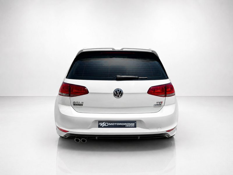 A-521_4jpg - OPSHOLDERS Rear view of a white Volkswagen Golf wagon in a bright studio, showing red tail lights and rear windshield wiper.