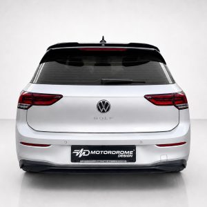 A-522_3jpg - OPSHOLDERS Rear view of a silver Volkswagen Golf hatchback in a studio setting, showing taillights and VW emblem on the trunk lid with a Motorodrome Design plate below.