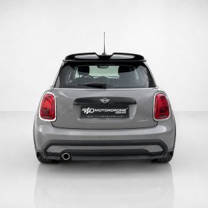 Rear view of a gray Mini Cooper with red taillights, roof rails, and a black license plate area reading MOTOR DROME DESIGN (Motordrome Design)
