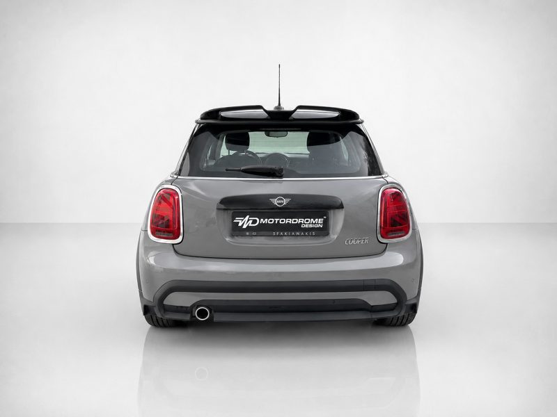 Rear view of a gray Mini Cooper with red taillights, roof rails, and a black license plate area reading MOTOR DROME DESIGN (Motordrome Design)