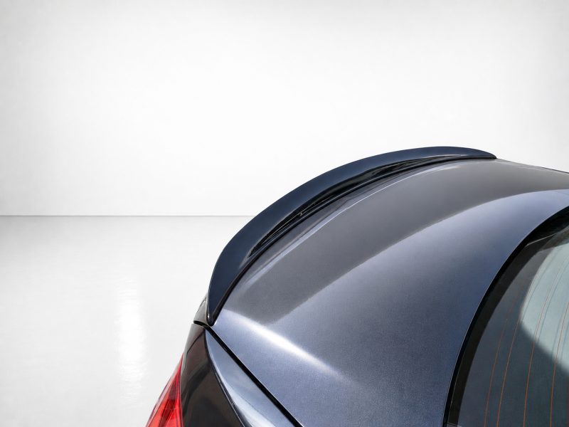 Close-up of the rear roofline of a metallic blue car, showing the curved window and glossy surface.