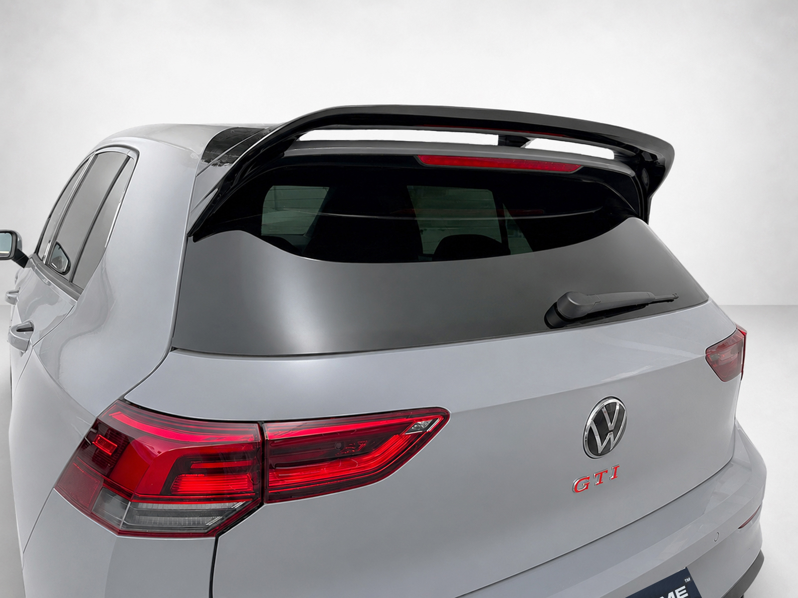 A-525_1jpg - OPSHOLDERS Rear view of a silver VW GTI hatchback with a large roof spoiler and tinted rear window